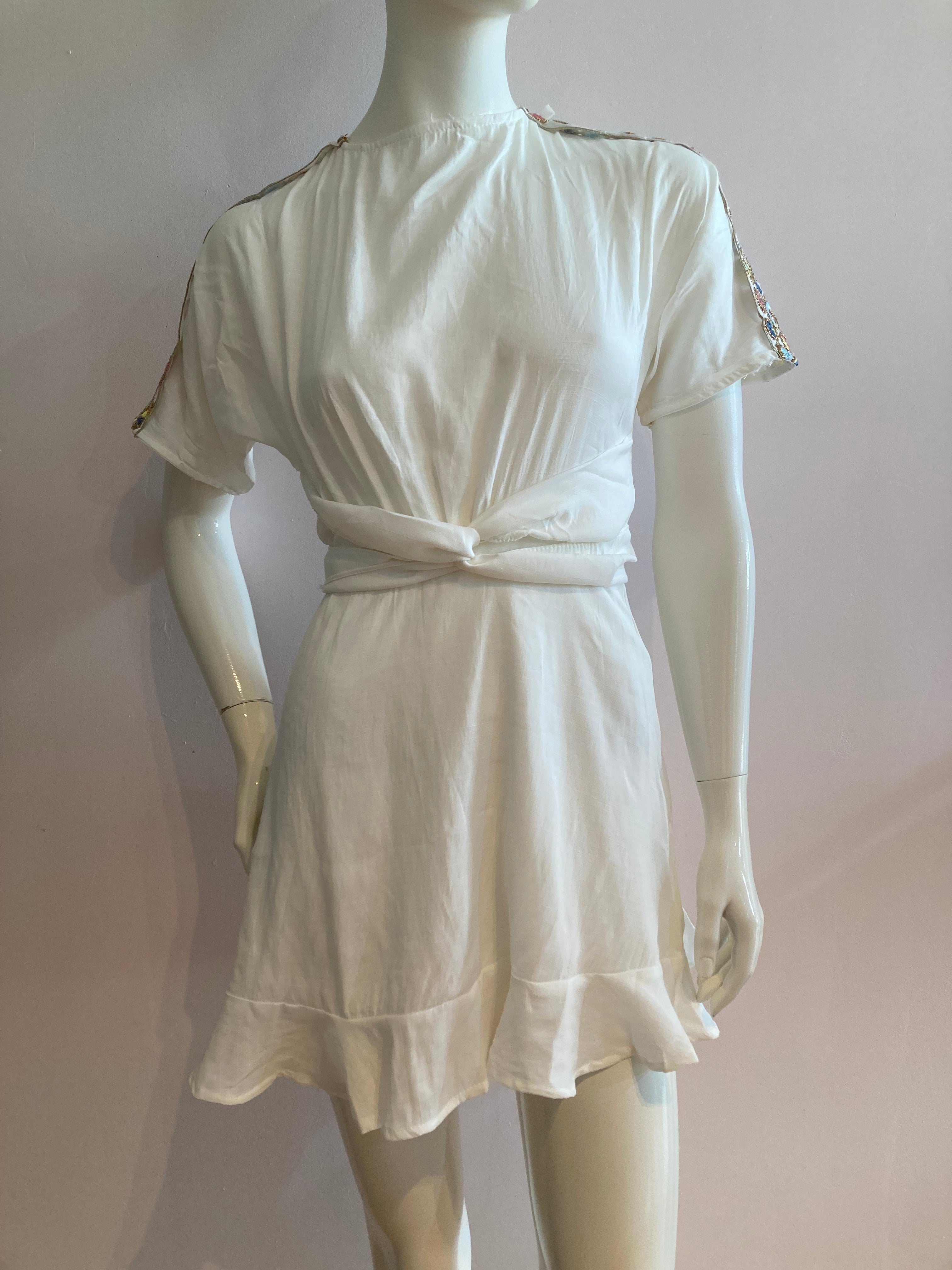 White skater dress with gold and colored yoke on the arms and open back